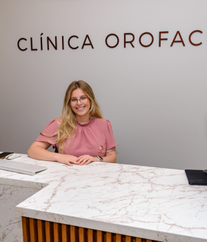 Recepcionista sorrindo na recepção da clínica Harmodont em Sorocaba, transmitindo acolhimento e atendimento humanizado.